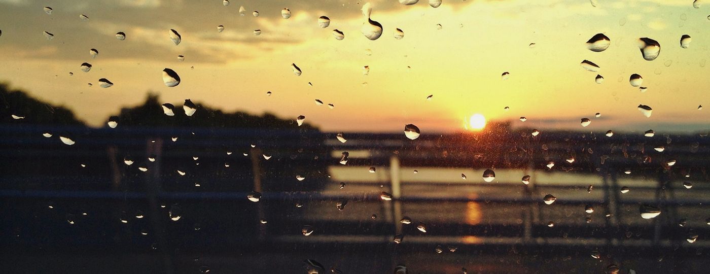 O que fazer em Salvador com chuva: janela molhada com por do sol de fundo