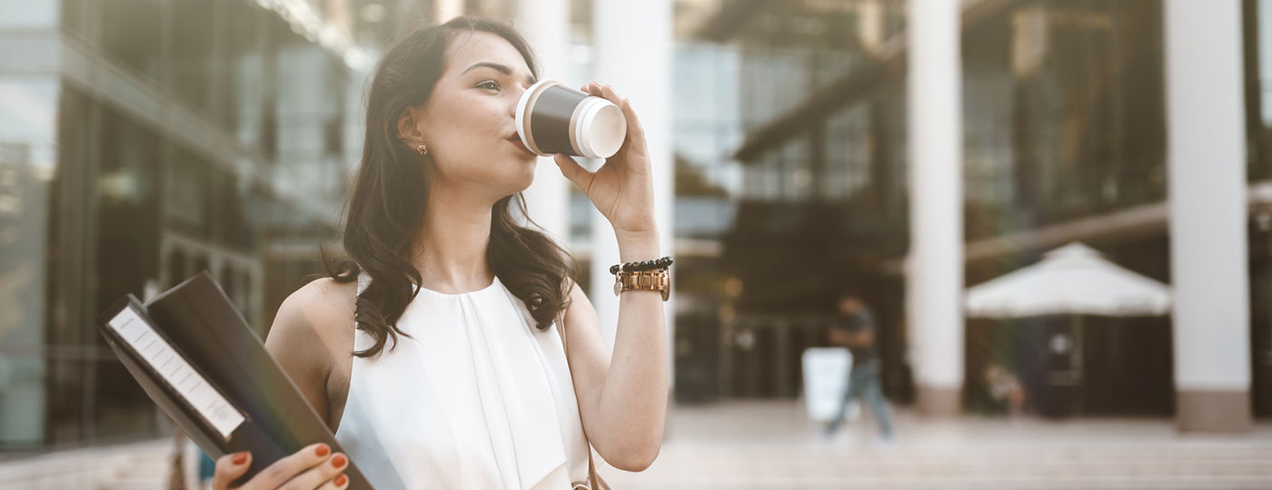 Una mujer de negocios bebe un café después del trabajo